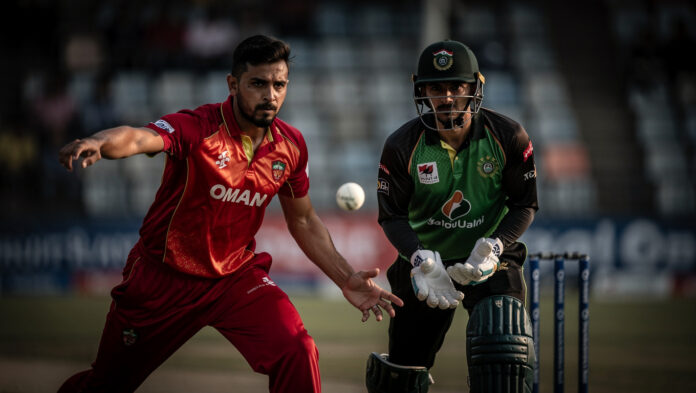 Oman vs UAE Face-Off: ICC Men's CWC League 2 Showdown Oman bowler and UAE batter in intense face-off, dramatic close-up at Tribhuvan University International Cricket Ground.